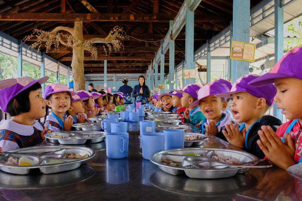 Betende Kinder in der Mensa einer Grundschule in Bangkok