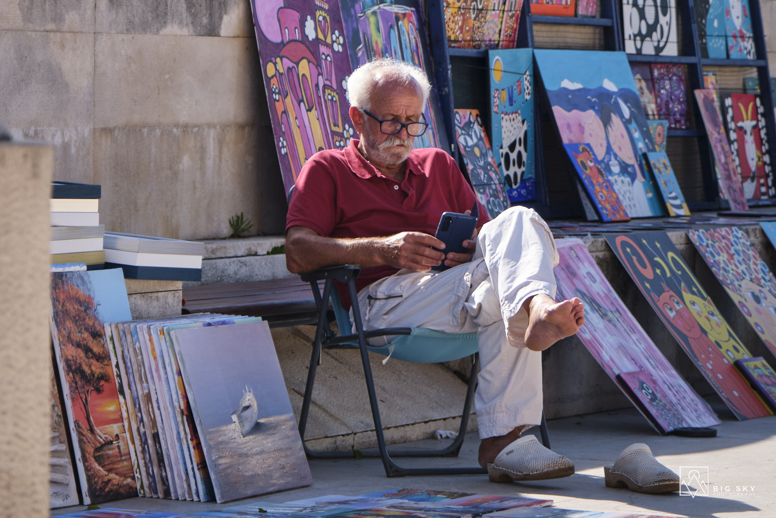 Ein Maler auf dem Markt in Zadar wartet vor seinen Bilder auf Käufer