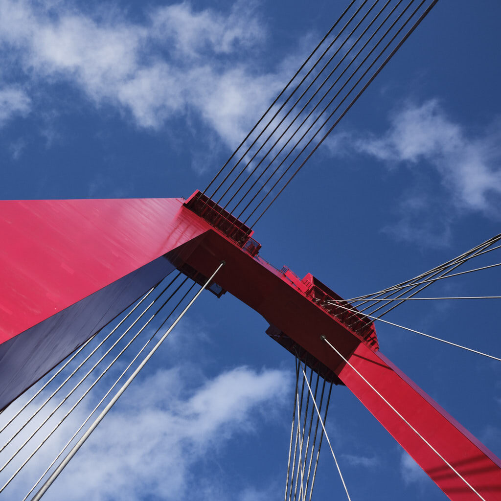 Rote Wilhelmsbrücke unter blauem Himmel in Rotterdam