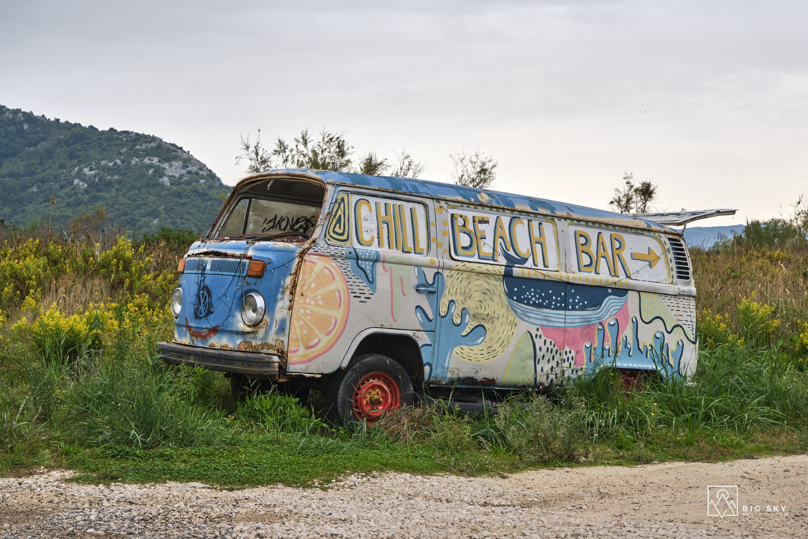 Ein alter bemalter VW-Bulli im Neretva-Delta dient als Hinweisschild für eine Strandbar