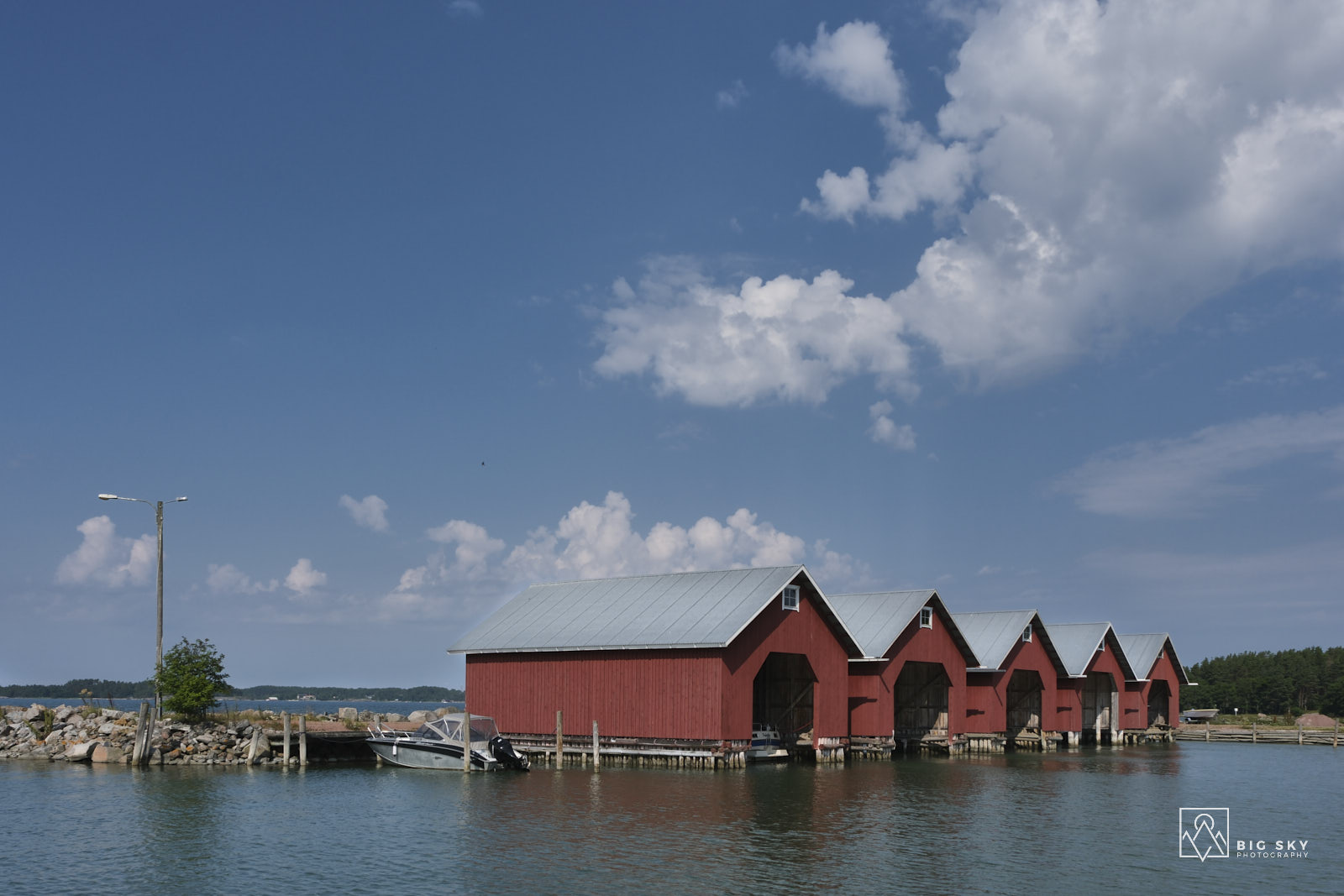 Der kleine Hafen Söderby mit roten Bootshäusern auf der Insel Inioe in Finnlands Schärengarten