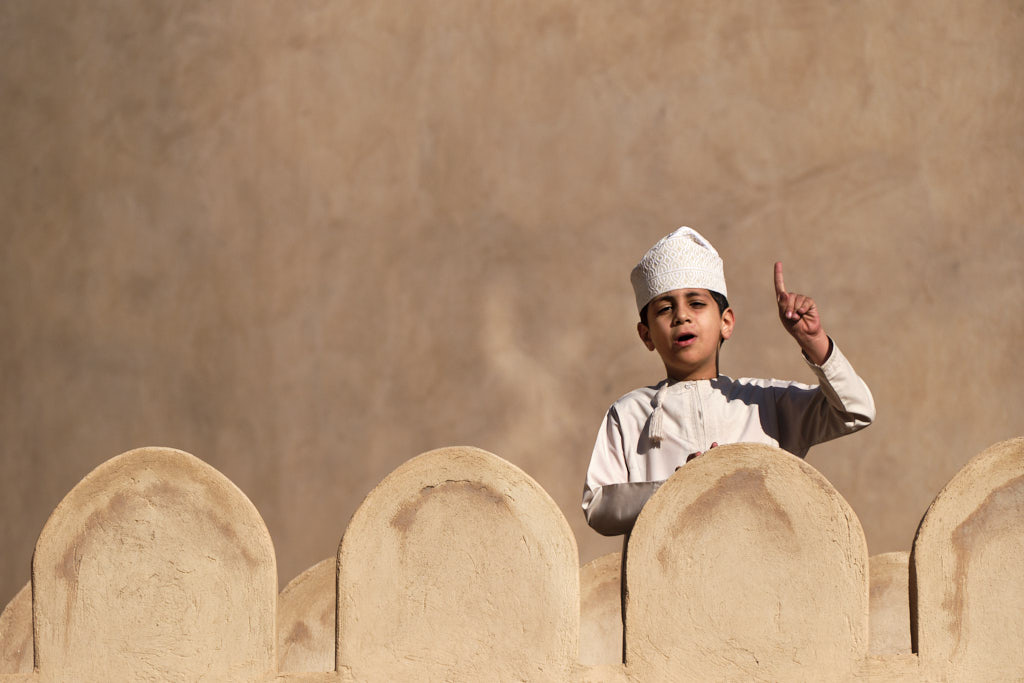 Junge mit traditioneller Kopfbedeckung (Kumma) und landestypischem Gewand (Dishdasha) im Nizwa Fort