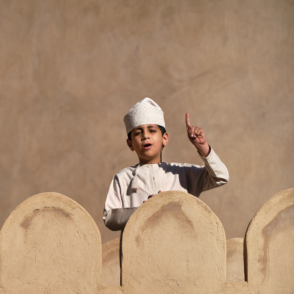 Junge mit traditioneller Kopfbedeckung (Kumma) und landestypischem Gewand (Dishdasha) im Nizwa Fort