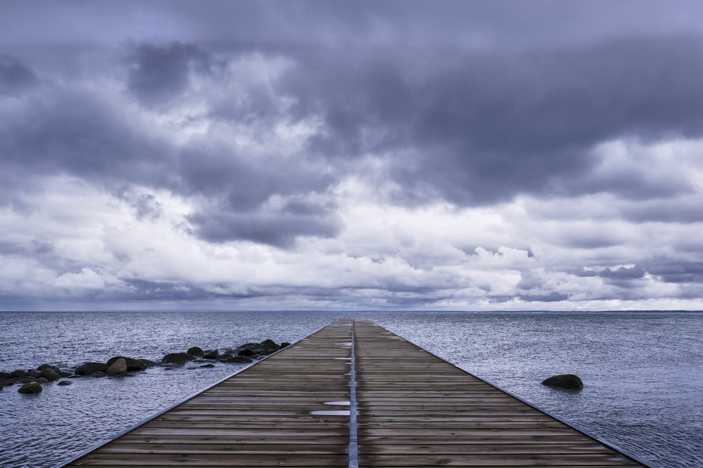 Holzsteg der in Norrviken ins Meer führt