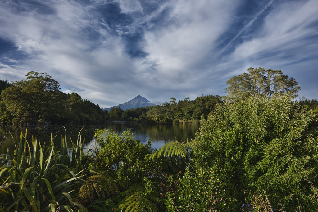 Der Mount Taranaki unter weißblauem Himmel in den frühen Abendstunden.