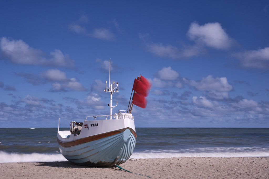 Fischerboot mit flatternden Fahnen am Strand von Vorupør im Nationalpark Thy im Nordwesten Jütlands