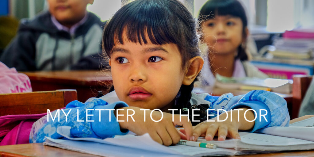 Thailändisches Schulmädchen in Bangkok vor einem Schulheft